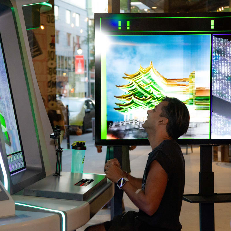 A man standing in front of a Dimension Plus screen, playing AI Street Fighting