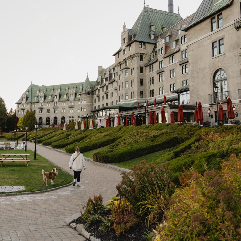 Femme avec un chien devant le Fairmont Manoir Richelieu