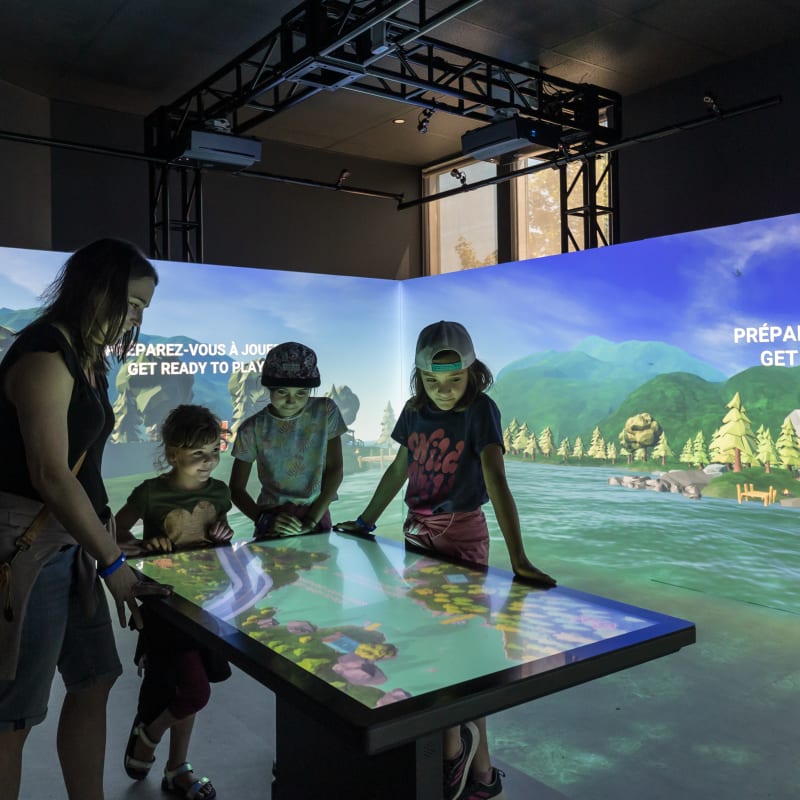 4 enfants autour d'une console interactive à l'exposition Acoatica.