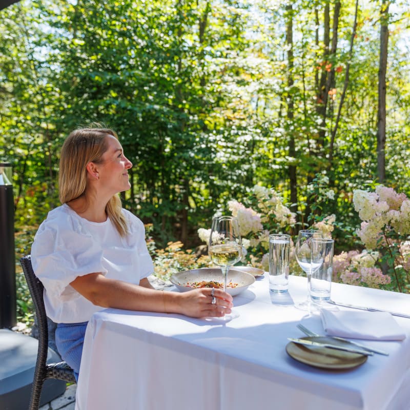 Femme assise à une table d'une terrasse