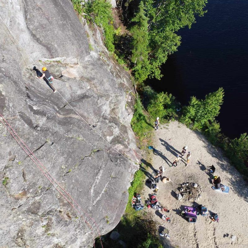 Vue en plongée d'un groupe de grimpeurs au pas d'une paroi d'escalade