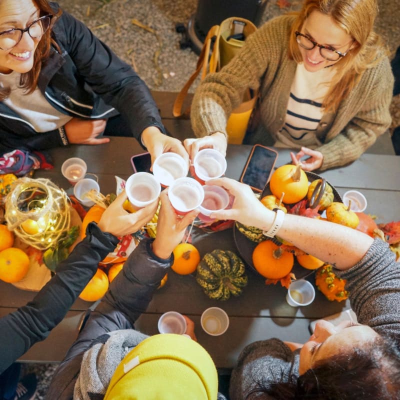 Groupe de femmes autour d'une table décorée de courges.