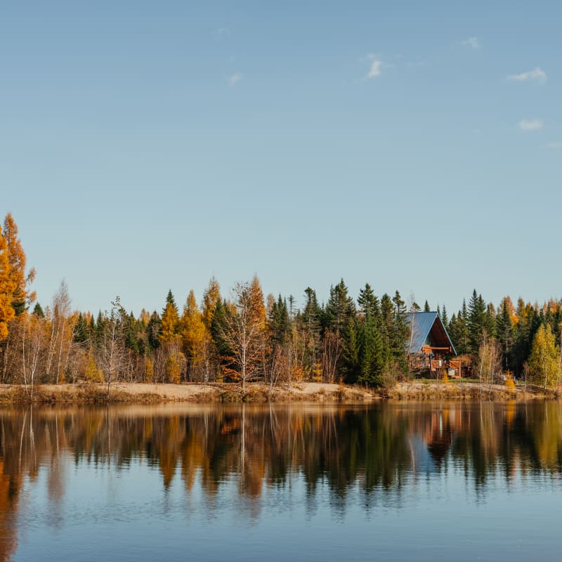 Chalet au bord d'un lac en automne Au Chalet en bois rond.