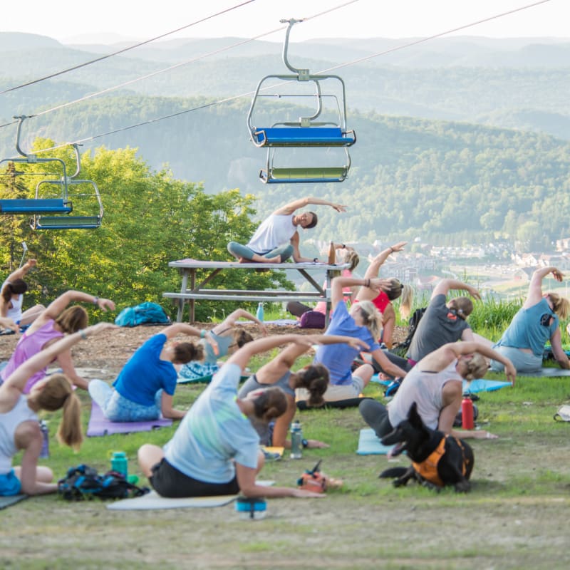 Groupe de personnes faisant du yoga sur une montagne